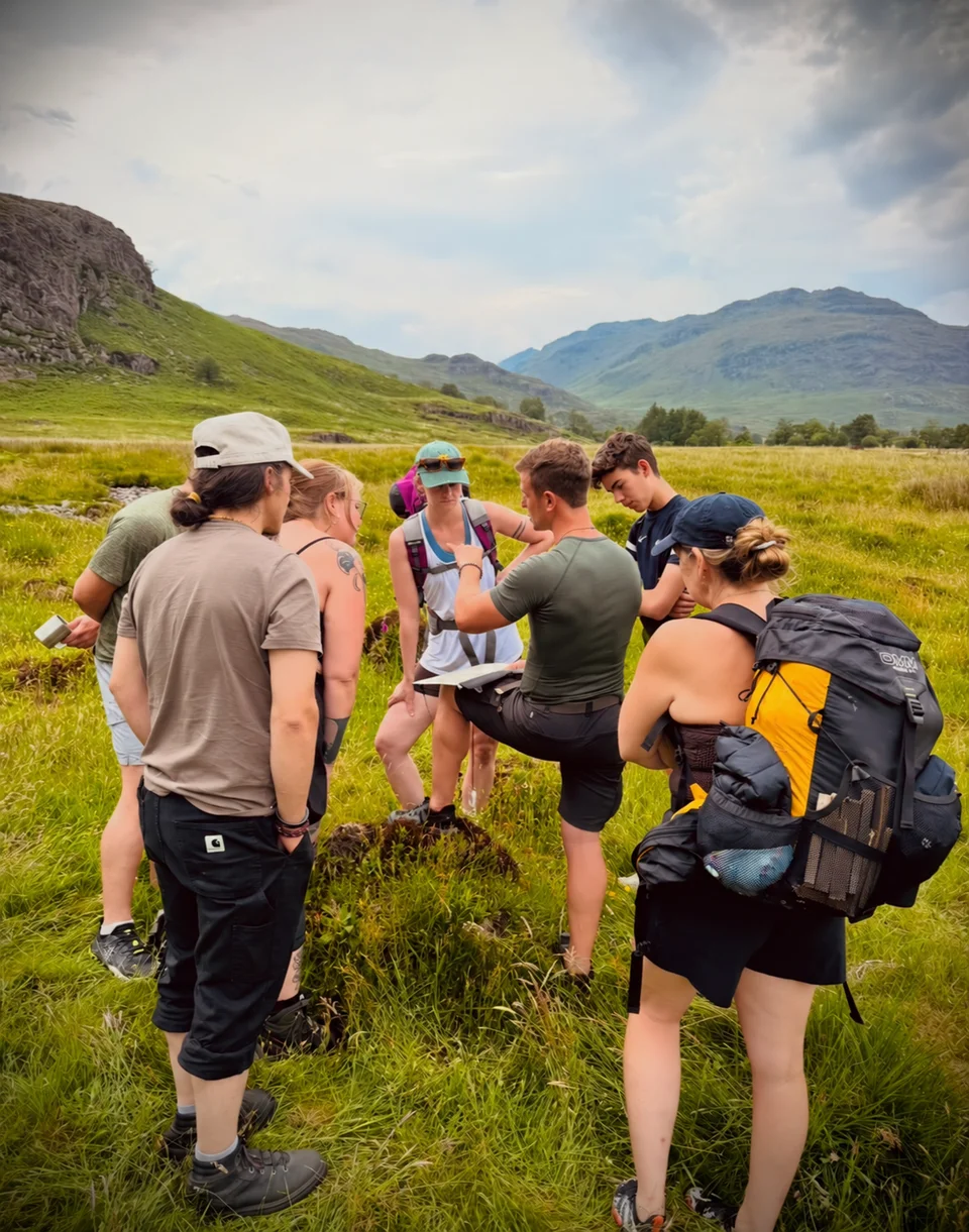 A hiking group gathered in a mountain meadow