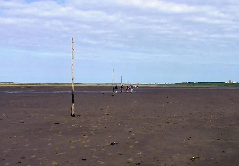 Walkers crossing the Pilgrim’s Way towards Holy Island, the finish of St Cuthbert’s Way