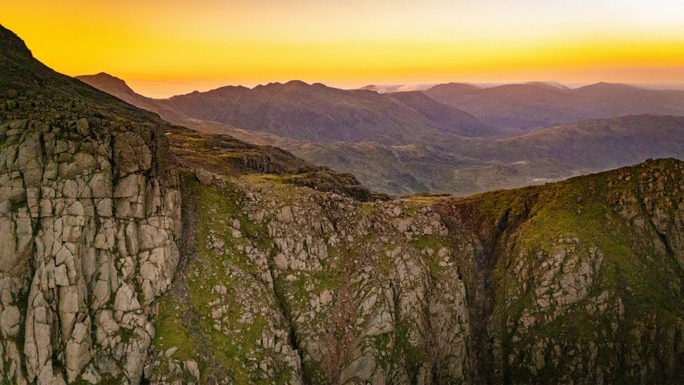 Rocky mountain ridges beneath a golden sunset