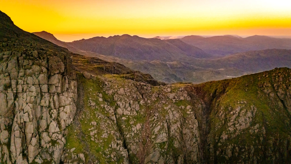 Rocky mountain ridges beneath a golden sunset