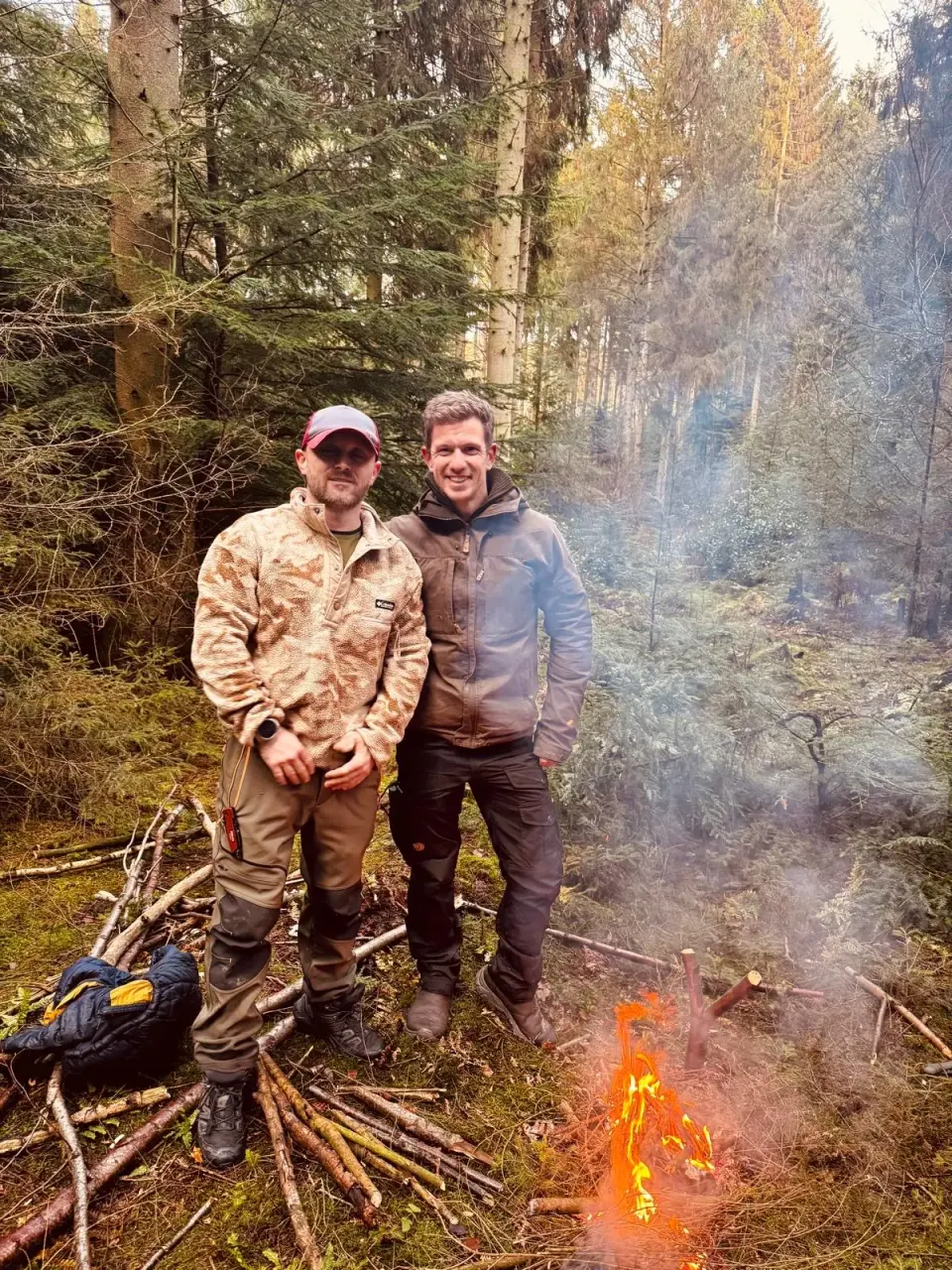 Tom and Dan beside a woodland fire